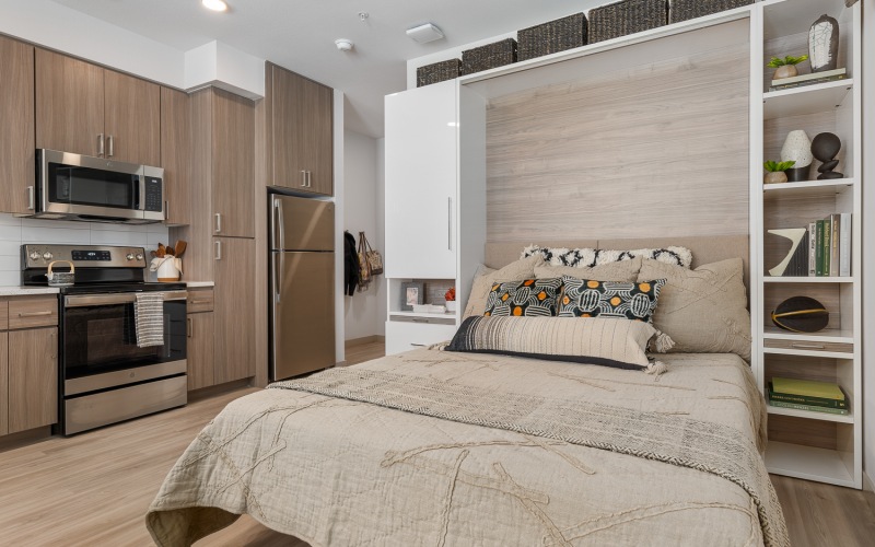 studio model with murphy bed, stainless steel appliances, and modern cabinetry