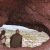 a man and woman looking out of a cave
