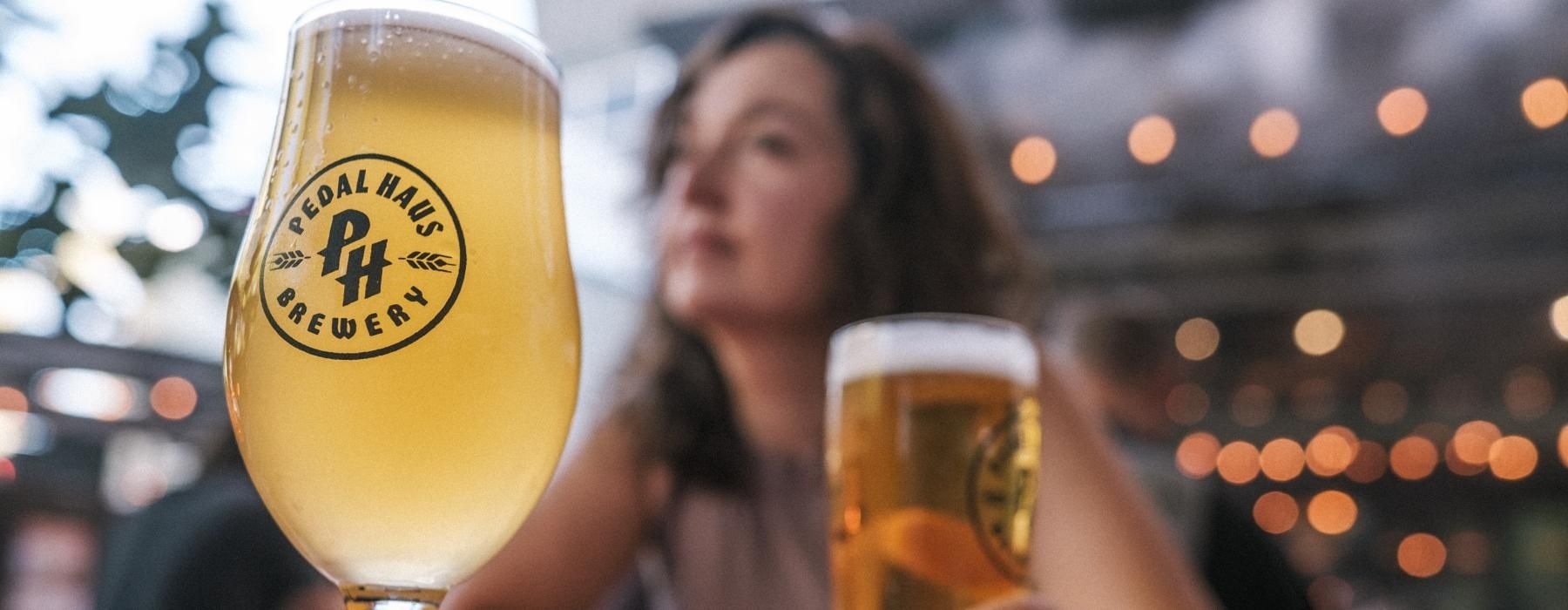 a person sitting at a table with two glasses of beer